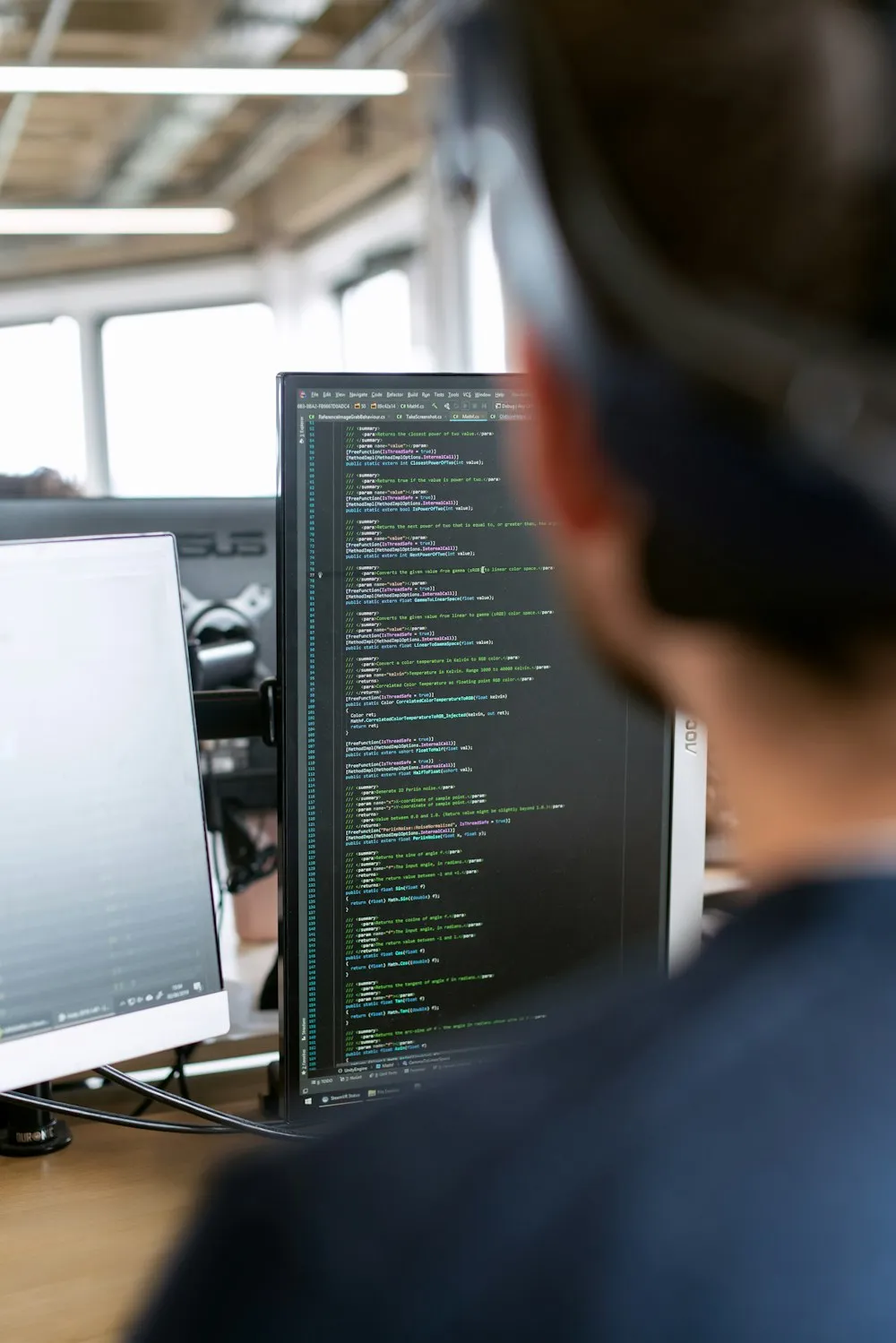 Desarrollador trabajando frente a varios monitores